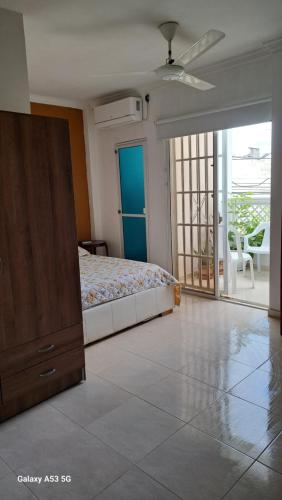 Un dormitorio con una cama y una puerta corrediza de vidrio. en Arriendo habitaciones amobladas con aire acondicionado, en Montería