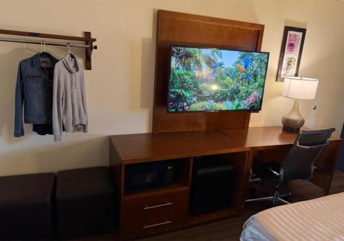a hotel room with a tv and a desk with a bed at Valley Inn in Phoenix