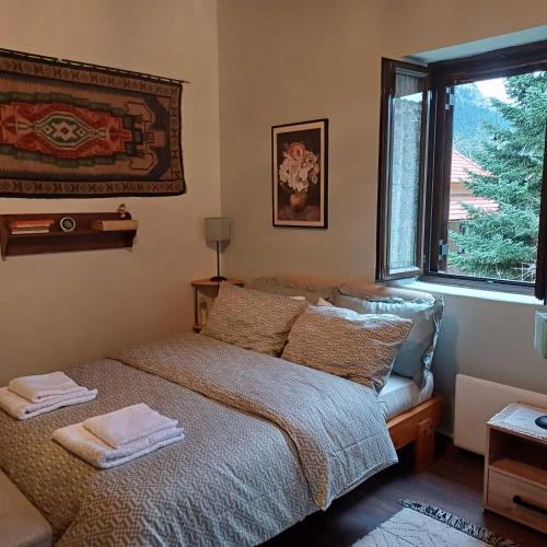 a bedroom with a bed with two towels on it at Vrachni Stone House in Kalavrita