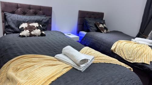 a bedroom with two beds with towels on them at Chic Above Store in Tredegar