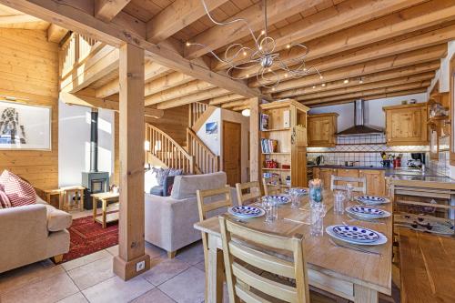een keuken en woonkamer met een tafel en stoelen bij Chalets d'en haut - Bonheur - Happy Rentals in Chamonix-Mont-Blanc