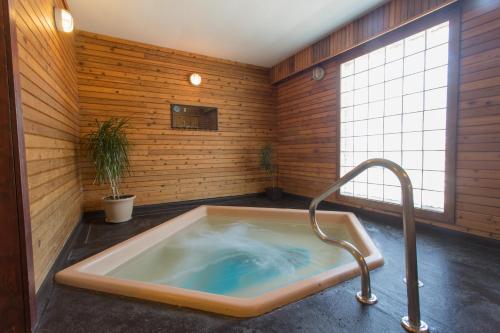 a jacuzzi tub in a room with wooden walls at Powder Mountain Lodge in Fernie