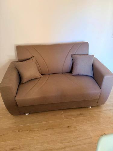 a brown couch in a room with two pillows at La DA MA Shila Winter Escape in Francavilla al Mare