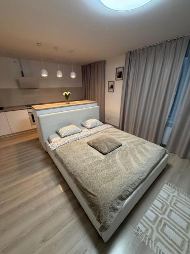 a bedroom with a large white bed with two pillows at Compleks by Karlus in Jelgava