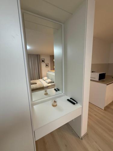 a mirror in a white room with a bed at Compleks by Karlus in Jelgava