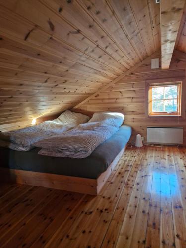 un letto in una stanza con soffitto in legno di Fjellvang a Haglebu