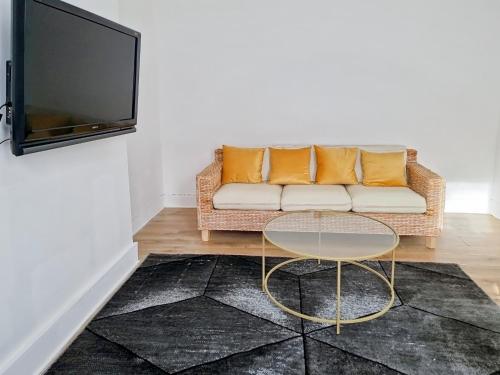 a living room with a couch and a table and a tv at Evo Yellow Gravesend 2 bed Apartment - 2 mins STN Town Centre in Gravesend