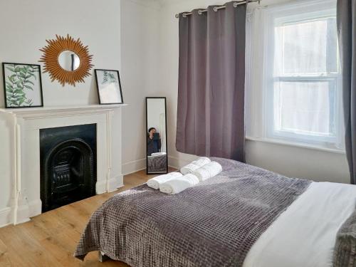 a bedroom with a bed and a fireplace and a mirror at Evo Yellow Gravesend 2 bed Apartment - 2 mins STN Town Centre in Gravesend