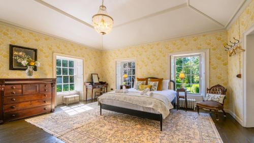 a bedroom with a bed and a dresser and windows at Tullymurry House in Ardarragh