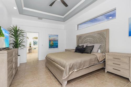 a bedroom with a bed and a dresser at Coastal River Oasis in Cape Coral
