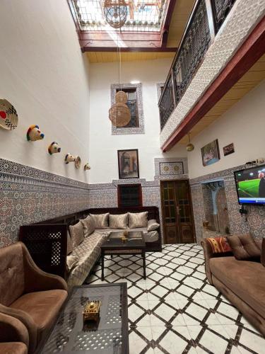 a living room with a couch and a tv at Dar Bab Boujloud Fez in Fez