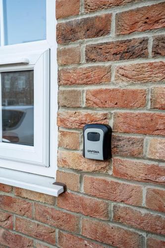 a tv on a brick wall next to a window at Modern Ensuite Studio with Free Parking in Stoke on Trent
