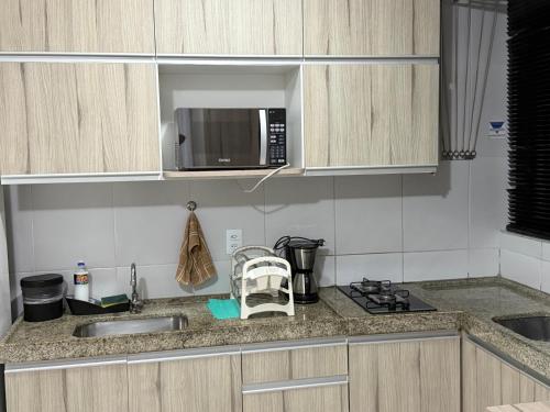 a kitchen with a sink and a microwave at Golden Point Apartamento em Recife in Recife