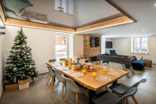 a dining room with a christmas tree and a table at Le Refuge de Lucien - OVO Network in Gérardmer