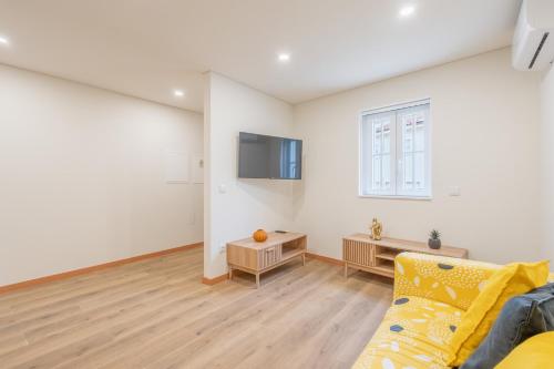 a living room with a couch and a window at A Casa da Sara in Braga