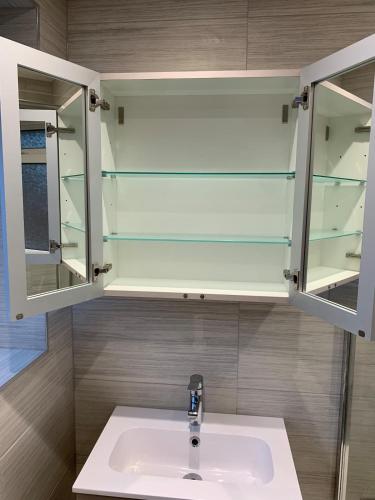 a bathroom with a sink and glass cabinets at Newly renovated countryside retreat in Scorton in Scorton