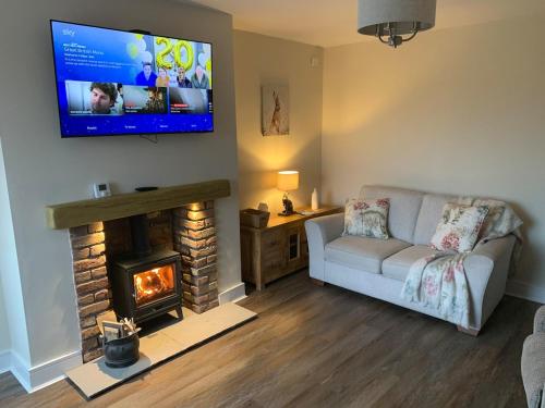 a living room with a couch and a fireplace at Newly renovated countryside retreat in Scorton in Scorton