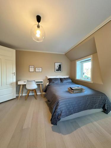 a bedroom with a bed and a desk in it at Norwegian Villa for 11 and great Views in Askøy
