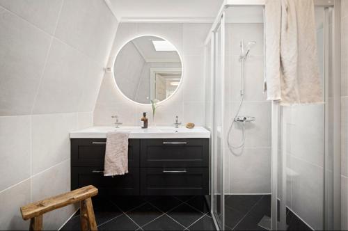 Un baño con lavabo y ducha con espejo. en Spacious Group Villa with Jacuzzi and Views, en Askøy