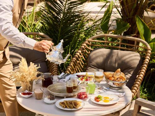 アガディールにあるSofitel Agadir Thalassa Sea & Spaのテーブル(上に食べ物と飲み物付)
