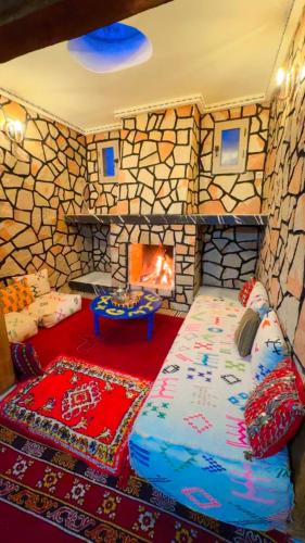 a room with a fireplace and a bed in a room at Villa Mouloud - Piscine partagée, nature et calme in Khenifra