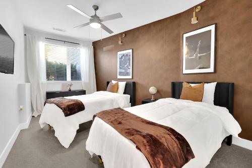 Luxury 2-Bedroom Apartment Near The Battery Atlanta with Pool, Sky Lounge & Free Parking في أتلانتا: غرفة نوم بها سريرين ومروحة سقف