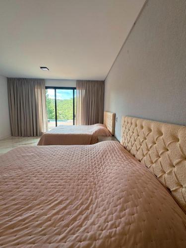 Ένα ή περισσότερα κρεβάτια σε δωμάτιο στο CASA MAGNÍFICA EM CAMPOS DO JORDÃO - Nova