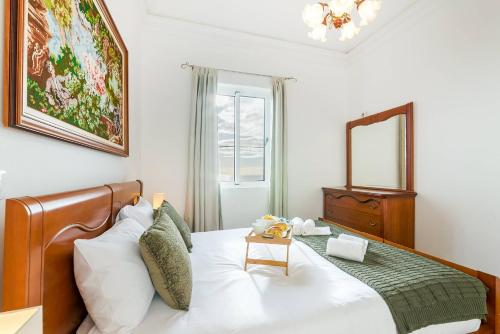 a bedroom with a bed and a mirror at Casa da Georgina by GALMI in Arco da Calheta