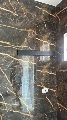 a bathroom with a black marble wall at Pousada Residencial A Dantas in Búzios