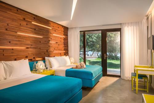 a hotel room with two beds and a blue couch at Astoria Palawan in Puerto Princesa City
