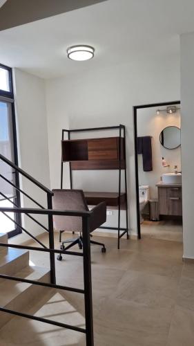 a chair sitting in a room with a bathroom at Casa de Las Olas in La Paz