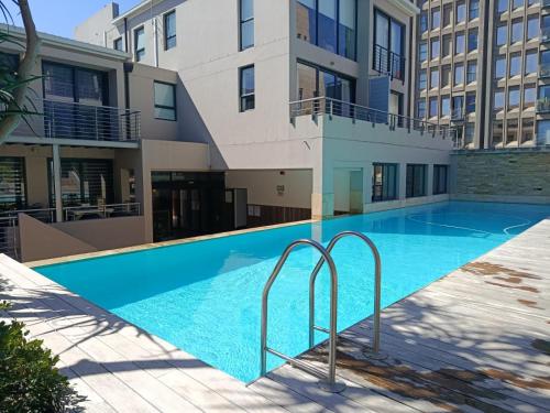 Cape Town CBD Pool Near CTICC Parliament Waterfront في كيب تاون: حمام سباحة أمام مبنى