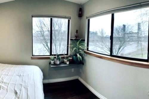um quarto com uma cama e duas janelas em Waterfront Condo, 25ft from riverwalk, Pool & HotTub em Portland