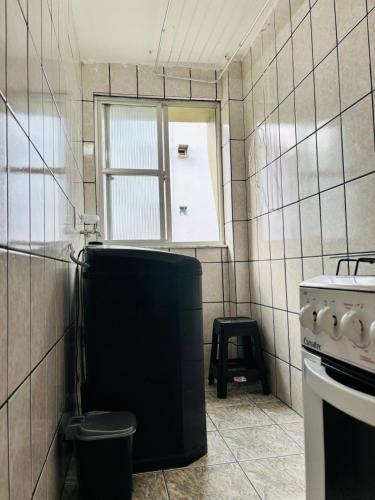 a kitchen with a trash can and a window at Enseada Azul Home in Guarapari