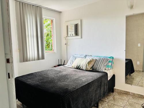 a bedroom with a bed and a window at Enseada Azul Home in Guarapari