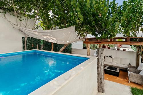 een zwembad in de achtertuin met een hangmat bij Villa Lol Tun Breakfast and Beach Club Included in Isla Mujeres