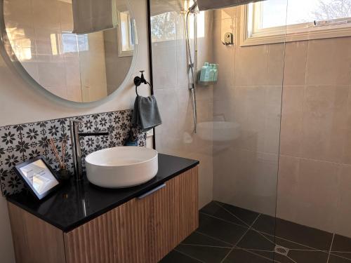 a bathroom with a sink and a mirror at Queensly Cottage in Portland