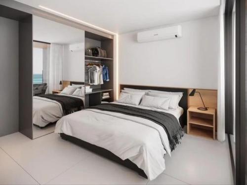 a bedroom with two beds and a mirror at Porto de Galinhas, Muro alto - PÉ NA AREIA in Ipojuca