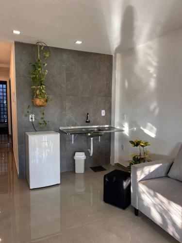 een woonkamer met een wastafel en een bank bij Oásis 6 prática e bem localizada e minimalista in Brasilia