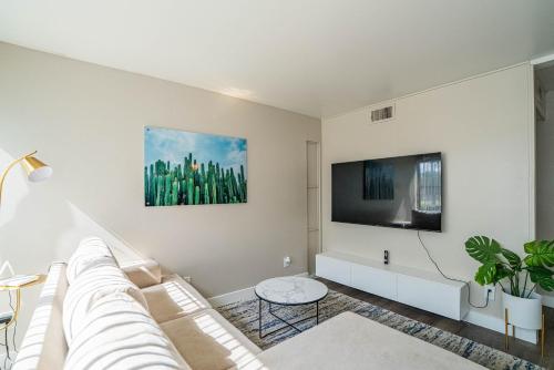 a white living room with a couch and a tv at Spacious 2 Bedroom, 2 Bath, Pool, Free Parking, Gym in Scottsdale