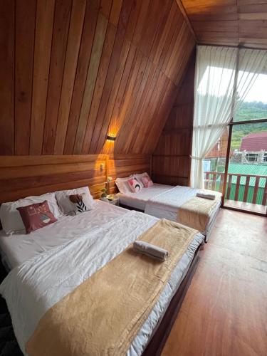 En eller flere senge i et værelse på Cabin Hillside Dieng