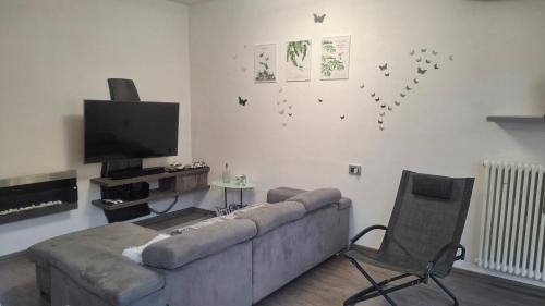 a living room with a couch and a tv and a chair at GS Valtellina in Morbegno