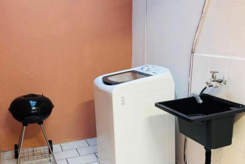 a bathroom with a trash can and a sink at Casa aconchegante pertinho da Praia Central in Itapema