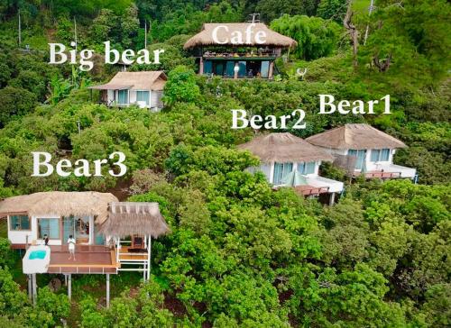 a group of houses on a hill with trees at bearhousecafe in Mae Sai