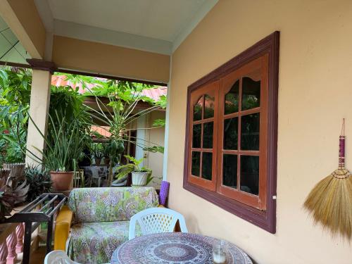 a patio with a chair and a table and a window at Elephant bungalow at Ya Nui beach in Phuket Town
