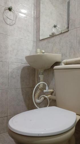 a bathroom with a white toilet and a sink at Paradise Hostel Recife Sul in Recife