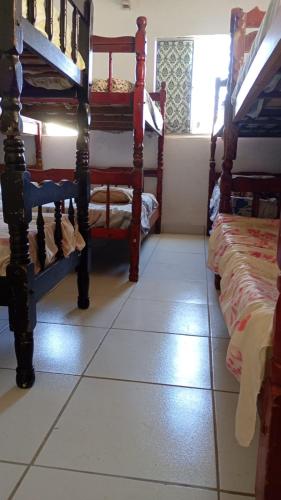 a room with two beds and a tiled floor at Paradise Hostel Recife Sul in Recife