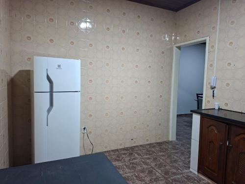 a kitchen with a white refrigerator in a room at Residencial Paraviana-Casa Piscina in Boa Vista