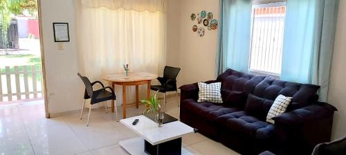 una sala de estar con un sofá y una mesa en Casa familiar completa con patio grande y estacionamiento en zona tranquila, en Ciudad del Este