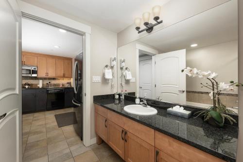 a bathroom with a sink and a large mirror at Ski-In / Ski-Out 1 Bedroom Condo base of WP Resort in Winter Park